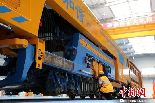 圖為工人正在清理大型養(yǎng)路機械?！堖h 攝